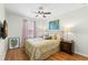 Cozy bedroom features a ceiling fan, window with curtains, a comfortable bed, and decorative wall art at 19487 Roseate Dr, Lutz, FL 33558