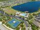 Aerial view of community pool with tennis courts, parking, and lake access at 19487 Roseate Dr, Lutz, FL 33558