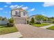 Charming two-story home featuring a manicured lawn and brick-paved driveway at 19487 Roseate Dr, Lutz, FL 33558