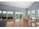 Bright dining room featuring hardwood floors, sliding glass doors and a modern ceiling fan at 19727 Gulf Blvd # 210, Indian Shores, FL 33785