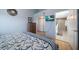 Comfortable main bedroom with ensuite bathroom, TV, hardwood floors and light blue walls at 19727 Gulf Blvd # 210, Indian Shores, FL 33785
