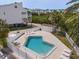 A private pool surrounded by lounge chairs, lush landscaping and a privacy fence at 19727 Gulf Blvd # 210, Indian Shores, FL 33785