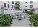 Outdoor seating area with a fire pit, white chairs, and lush landscaping, perfect for socializing with neighbors at 199 Dali Blvd # 902, St Petersburg, FL 33701