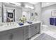 Modern bathroom with dual sinks, gray cabinets, and separate toilet room at 199 Dali Blvd # 902, St Petersburg, FL 33701
