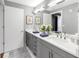 Bright bathroom featuring dual sinks, white countertops and grey cabinets at 199 Dali Blvd # 902, St Petersburg, FL 33701