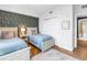 This bedroom features twin beds, beautiful wallpaper, and wood floors at 199 Dali Blvd # 902, St Petersburg, FL 33701