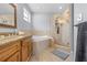 Bright bathroom with a drop in tub, glass door shower, and wooden vanity at 212 N Bradford Ave, Tampa, FL 33609