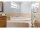 Bright bathroom featuring a drop in tub with tile surround and glass door shower at 212 N Bradford Ave, Tampa, FL 33609