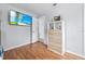 Bedroom featuring wood floors, shelving and a mounted flat screen television at 212 N Bradford Ave, Tampa, FL 33609