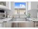 Farmhouse style kitchen sink under a window with modern faucet and gray countertops at 212 N Bradford Ave, Tampa, FL 33609