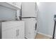 Functional laundry area featuring a stacked washer and dryer unit, sink, and cabinet at 212 N Bradford Ave, Tampa, FL 33609
