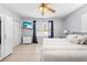 Main bedroom with mounted TV, ceiling fan, tile floors, and windows with curtains at 212 N Bradford Ave, Tampa, FL 33609
