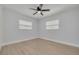 Bedroom with neutral walls, two windows, wood floors, and a ceiling fan providing a comfortable retreat at 2156 Greenbriar Blvd, Clearwater, FL 33763