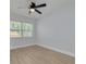 A bright bedroom with hardwood floors, ceiling fan and a large window at 2156 Greenbriar Blvd, Clearwater, FL 33763