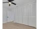 Bedroom features new flooring, a ceiling fan, and a closet providing ample storage at 2156 Greenbriar Blvd, Clearwater, FL 33763