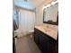 Bright bathroom features tiled shower with a white curtain and wooden vanity at 2904 W Marlin Ave, Tampa, FL 33611
