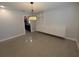 Dining room with views to kitchen and storage featuring decorative light fixture and polished concrete floors at 2904 W Marlin Ave, Tampa, FL 33611