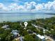 An aerial view of a residential neighborhood featuring mature trees and a large body of water in the background at 3005 W Helen Ave, Tampa, FL 33611
