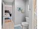 Well-lit half-bathroom with a toilet and view to a bedroom, featuring neutral decor and modern fixtures at 3005 W Helen Ave, Tampa, FL 33611