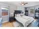 Spacious bedroom with a black-framed bed, hardwood floors, and windows, offering a comfortable and stylish retreat at 3005 W Helen Ave, Tampa, FL 33611