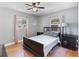 Cozy bedroom features hardwood floors, neutral paint, and windows with pink curtains for ample natural light at 3005 W Helen Ave, Tampa, FL 33611