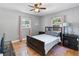 Cozy bedroom features hardwood floors, neutral paint, and windows with pink curtains for ample natural light at 3005 W Helen Ave, Tampa, FL 33611
