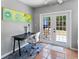 Bright sunroom featuring a desk, large window, and French doors to the backyard at 3005 W Helen Ave, Tampa, FL 33611