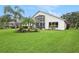 Backyard with a covered patio, lush lawn, tropical plants and impeccable landscaping at 3023 Bent Creek Dr, Valrico, FL 33596