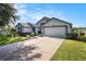 Spacious driveway leading to a two-car garage, complemented by well-maintained landscaping and a cozy front yard at 3023 Bent Creek Dr, Valrico, FL 33596