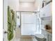 Bright bathroom featuring a glass shower, tiled walls, and a white cabinet for storage at 3078 Pointer Dr, Palm Harbor, FL 34683