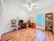 This bedroom has a desk, ceiling fan, hardwood floors, and natural light from the window at 3078 Pointer Dr, Palm Harbor, FL 34683