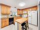 Well-equipped kitchen featuring wooden cabinets, appliances, and an island with bar seating at 3078 Pointer Dr, Palm Harbor, FL 34683