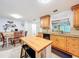 Kitchen view with island seating, wooden cabinetry, granite counters and adjacent dining space at 3078 Pointer Dr, Palm Harbor, FL 34683