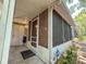 Exterior view of the screened-in front porch with a white door and plants at 3078 Pointer Dr, Palm Harbor, FL 34683