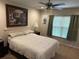 Comfortable bedroom with neutral tones, a ceiling fan, and bright natural light from the window at 3132 Royal Tuscan Ln, Valrico, FL 33594