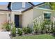 Close-up view of home's front entrance showcasing manicured garden, flower beds, and stylish exterior at 35029 Brackett Bnd, Zephyrhills, FL 33541