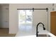 Modern kitchen featuring a quartz island with sink, stainless steel appliances, and sliding barn door detail at 3820 Pompano Se Dr, St Petersburg, FL 33705