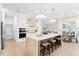 Bright kitchen featuring an island with seating, modern stainless steel appliances, and a view of the living and dining areas at 3982 Wellington Pkwy, Palm Harbor, FL 34685