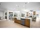 Open-concept kitchen featuring a central island with modern countertops and stainless steel appliances with adjacent living and dining areas at 3982 Wellington Pkwy, Palm Harbor, FL 34685