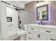 Updated bathroom features a shower-tub combo with decorative tiling and a modern white vanity at 4101 Hollowtrail Dr, Tampa, FL 33624
