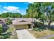 Eye-level exterior view of a cozy home with a stone facade, a palm tree, and a spacious driveway leading to the garage at 4101 Hollowtrail Dr, Tampa, FL 33624