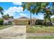 This single-Gathering home features a stone facade, a two-car garage, and a well-maintained lawn under a sunny sky at 4101 Hollowtrail Dr, Tampa, FL 33624