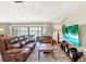 Spacious living room filled with natural light, featuring plush seating, a modern entertainment center, and access to the outdoors at 4101 Hollowtrail Dr, Tampa, FL 33624
