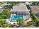 Aerial view of private screened-in pool area with turquoise water, surrounded by lush tropical landscaping at 4101 Hollowtrail Dr, Tampa, FL 33624