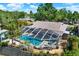 Aerial view of screened-in pool area and lush tropical landscape with privacy fence at 4101 Hollowtrail Dr, Tampa, FL 33624