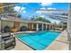 Beautiful backyard showcases a sparkling pool with a screened enclosure and outdoor seating area at 4101 Hollowtrail Dr, Tampa, FL 33624