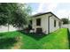 Backyard with green grass, partial tree coverage, patio with grill, and partial white fence at 4106 N Thatcher, Tampa, FL 33614