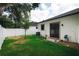 A beautiful backyard features green grass, a white fence and access to the home through sliding glass doors at 4106 N Thatcher, Tampa, FL 33614