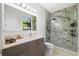 Bathroom with a gray vanity, white countertop, mirror, and a walk-in shower with marble-style tile at 4106 N Thatcher, Tampa, FL 33614