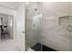 Contemporary bathroom with a glass shower featuring marble tile and a black tile floor at 4106 N Thatcher, Tampa, FL 33614